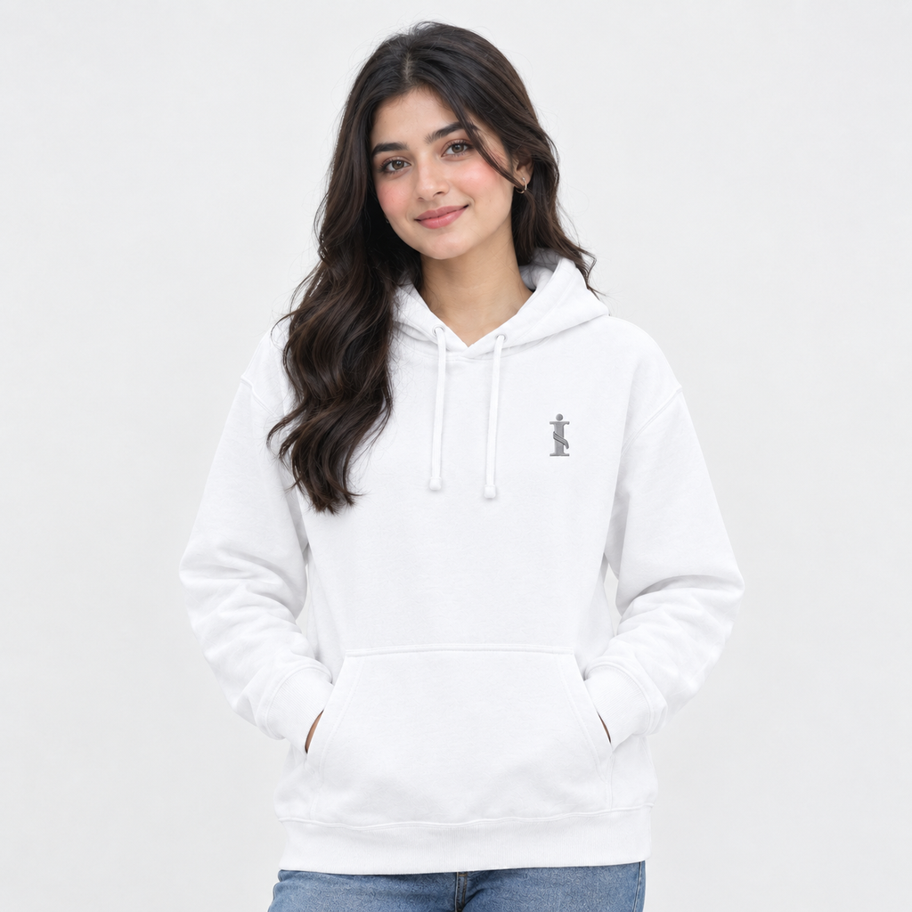 A woman with long dark hair wearing a white pullover hoodie with a small gray graphic on the left chest, paired with blue jeans, against a plain light gray background.